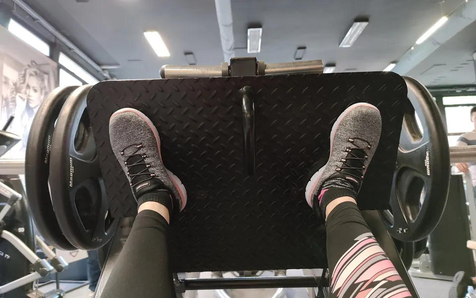Feet on the platform of a plate-loaded leg press machine